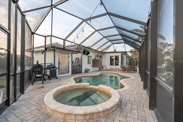 view of pool featuring area for grilling, a lanai, an in ground hot tub, and a patio