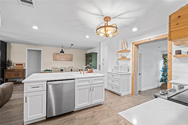 kitchen featuring light wood-type flooring, stainless steel appliances, sink, white cabinetry, and an island with sink