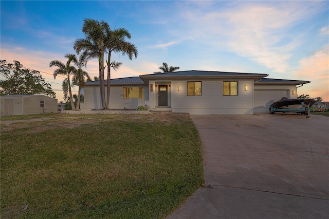 view of front of house featuring a garage and a lawn