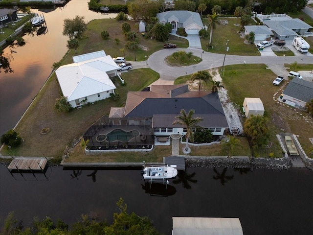 aerial view at dusk featuring a water view