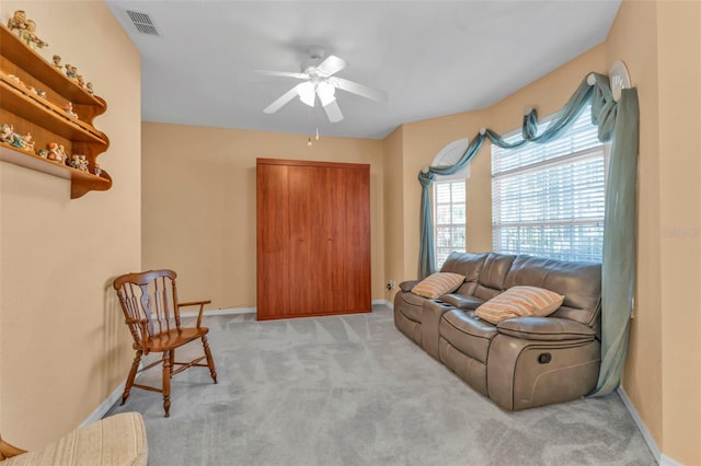 carpeted living room with ceiling fan