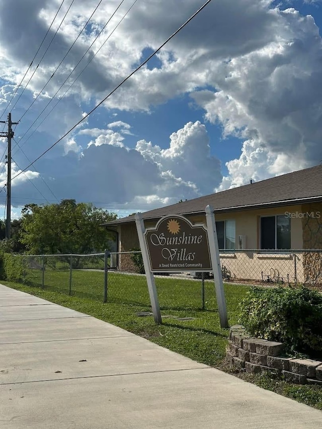 community / neighborhood sign featuring a yard