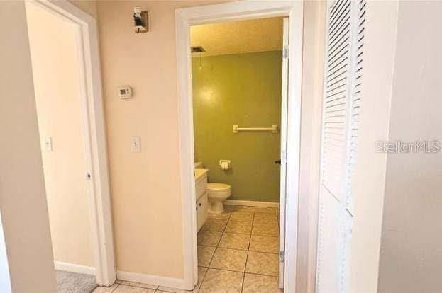 bathroom featuring vanity, tile patterned flooring, and toilet