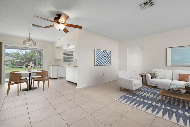 living room featuring light tile patterned floors, a textured ceiling, and ceiling fan