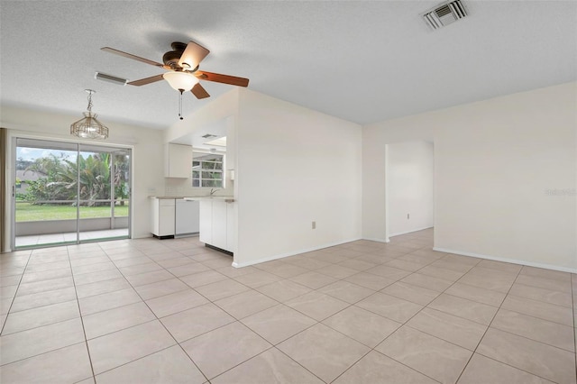 unfurnished living room featuring ceiling fan, light tile patterned floors, and a textured ceiling