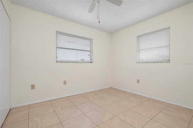 unfurnished room with a textured ceiling, ceiling fan, and light tile patterned flooring