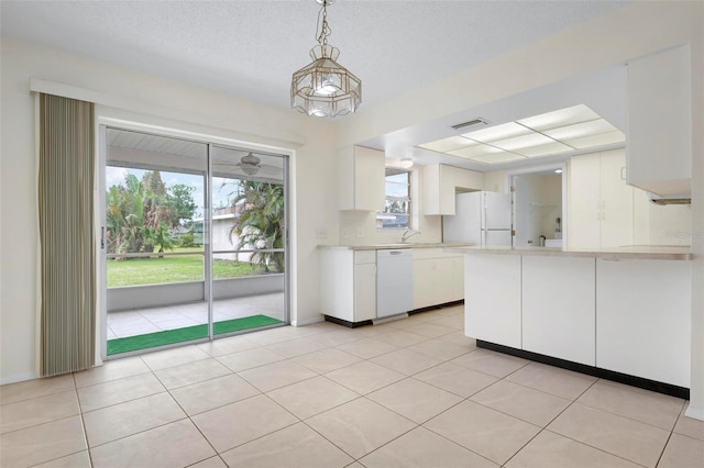 kitchen with decorative light fixtures, a healthy amount of sunlight, white appliances, and white cabinetry