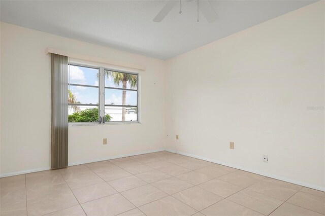 empty room with ceiling fan and light tile patterned flooring