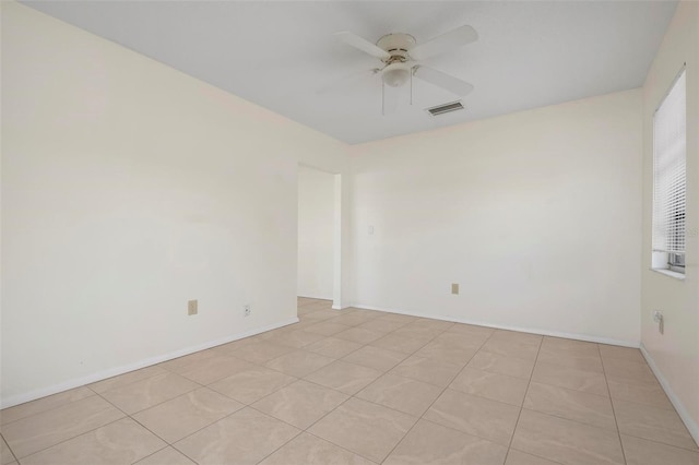 spare room featuring light tile patterned floors, plenty of natural light, and ceiling fan