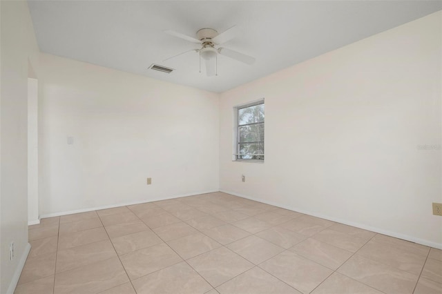 tiled spare room featuring ceiling fan