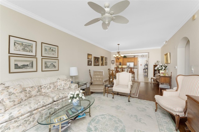 living room featuring light hardwood / wood-style floors, ceiling fan with notable chandelier, and ornamental molding