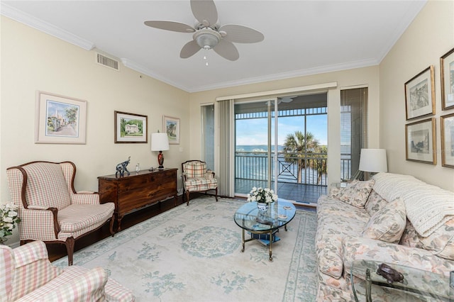 living room with a water view, ceiling fan, and ornamental molding