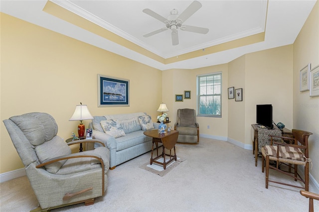 living room featuring a raised ceiling, ceiling fan, crown molding, and light carpet