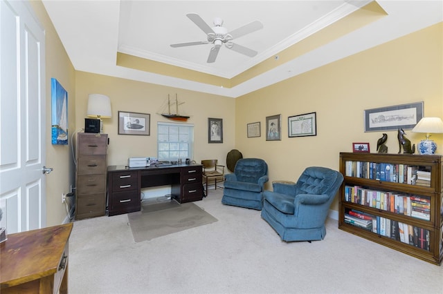 carpeted home office with a raised ceiling, ceiling fan, and crown molding