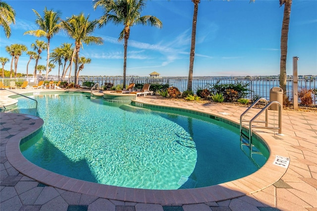 view of pool featuring a water view and a patio