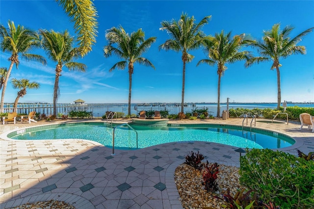 view of swimming pool with a patio area and a water view