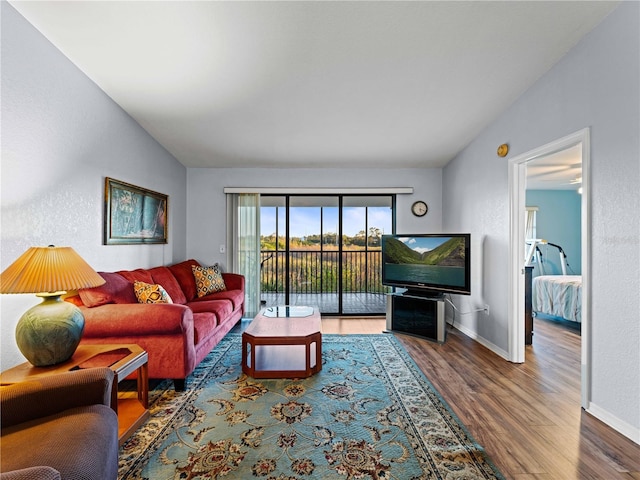 living room with hardwood / wood-style flooring and vaulted ceiling