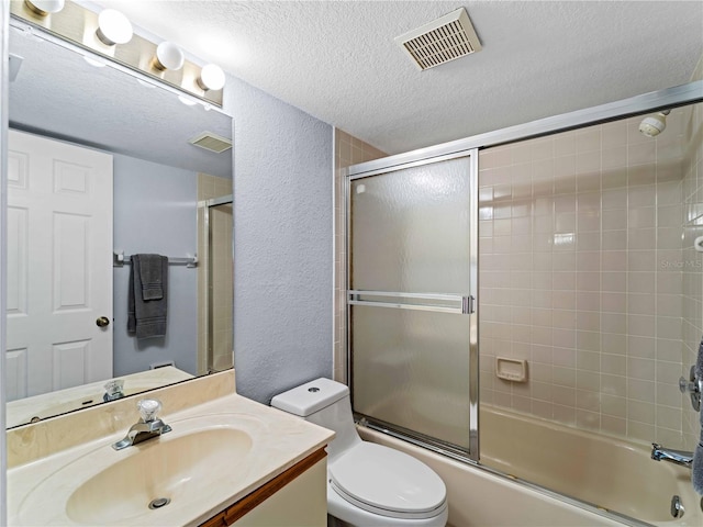 full bathroom with vanity, enclosed tub / shower combo, a textured ceiling, and toilet