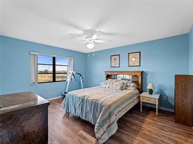 bedroom with ceiling fan and dark wood-type flooring