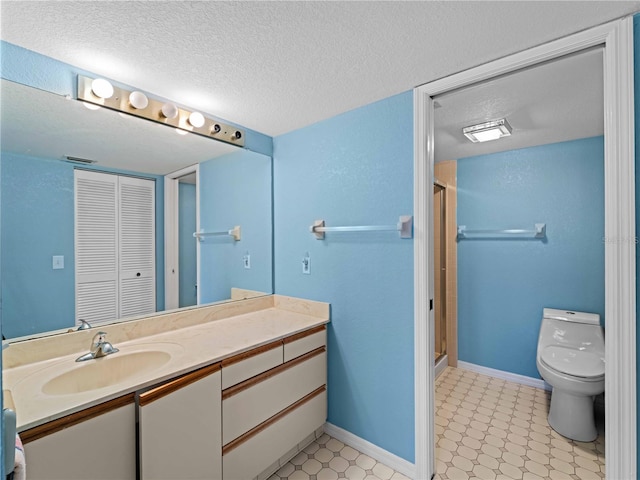 bathroom with a shower with door, vanity, a textured ceiling, and toilet