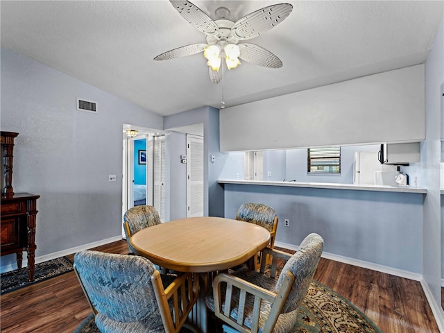 dining room with ceiling fan, dark hardwood / wood-style flooring, and vaulted ceiling