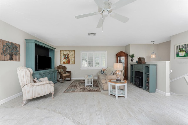 living room with ceiling fan and light hardwood / wood-style flooring