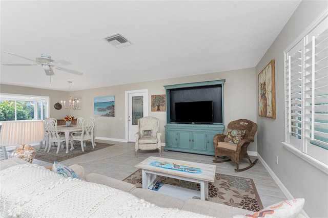 living room featuring ceiling fan with notable chandelier