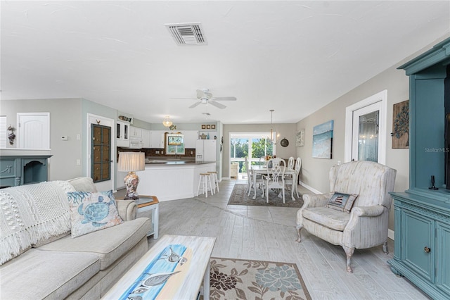 living room with ceiling fan and light hardwood / wood-style floors