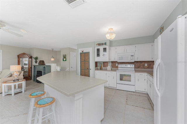 kitchen with white appliances, decorative backsplash, ceiling fan, decorative light fixtures, and white cabinetry