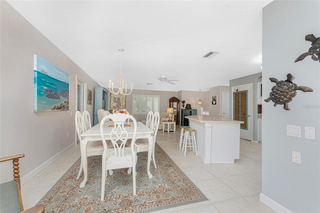 dining area with light tile patterned flooring and ceiling fan with notable chandelier