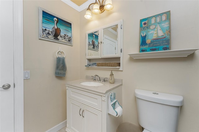 bathroom with crown molding, vanity, and toilet