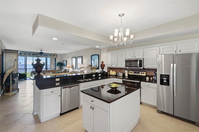 kitchen with white cabinets, a center island, kitchen peninsula, and stainless steel appliances