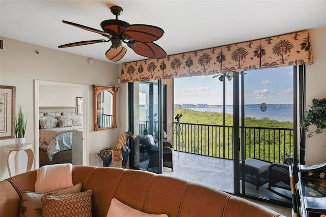 living room featuring ceiling fan and a water view