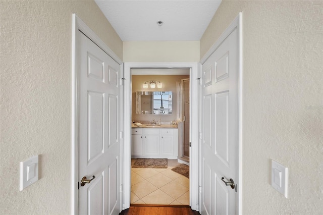 corridor with hardwood / wood-style floors and sink