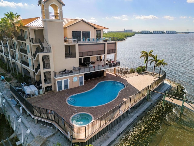 view of pool featuring a water view, a community hot tub, and a patio