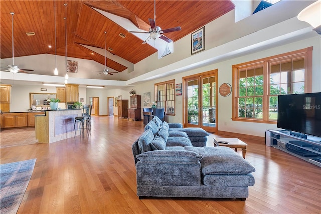 living room featuring ceiling fan, light wood-type flooring, wood ceiling, and a high ceiling