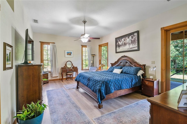 bedroom featuring access to exterior, light hardwood / wood-style flooring, and ceiling fan