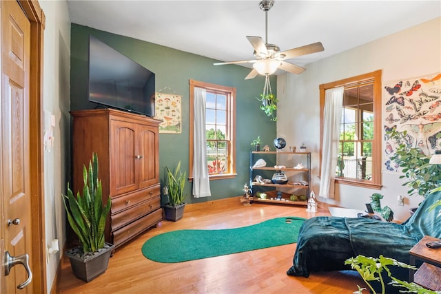 sitting room with a wealth of natural light, hardwood / wood-style floors, and ceiling fan