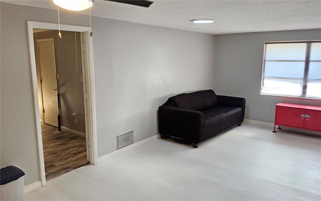 sitting room featuring ceiling fan and wood-type flooring