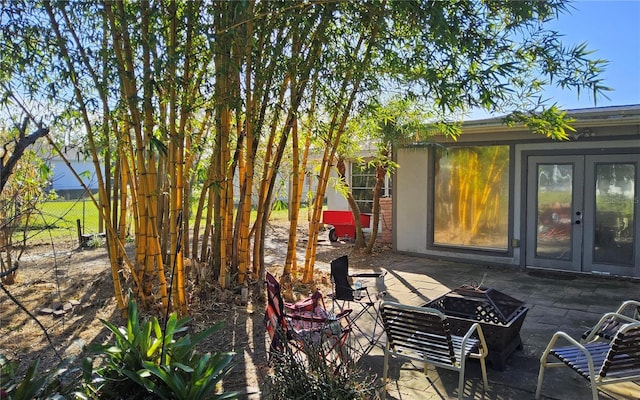 view of patio / terrace with french doors and a fire pit