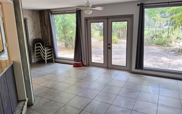 1108 Ample Ave, Port Charlotte, FL 33948 - doorway to outside featuring french doors, plenty of natural light, ceiling fan, a textured ceiling, and wood walls