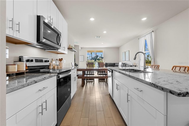 kitchen featuring light stone countertops, sink, white cabinetry, and stainless steel appliances