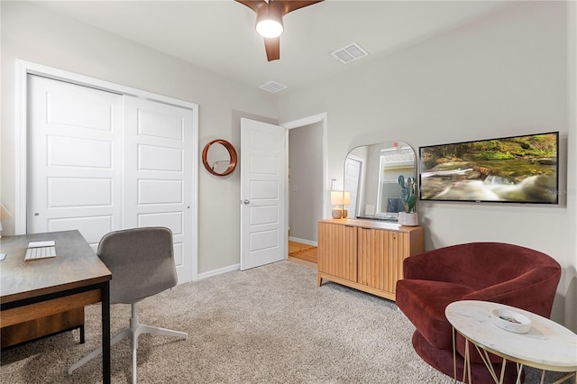 carpeted home office featuring ceiling fan