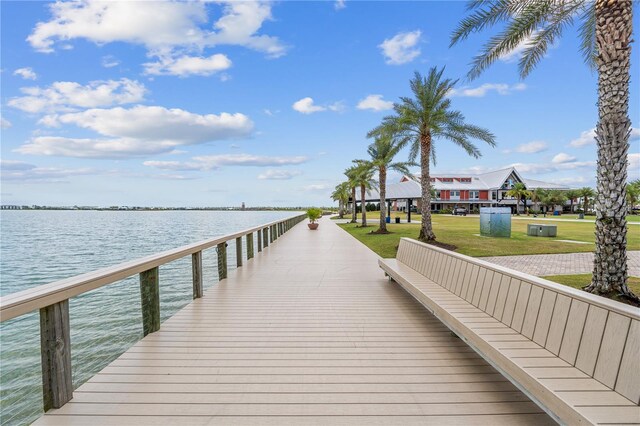 dock area with a lawn and a water view