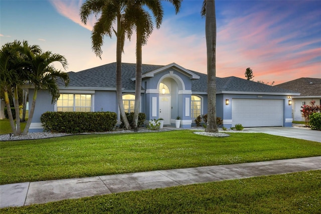 single story home featuring a lawn and a garage