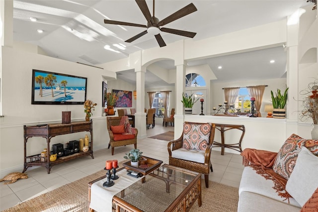 living room featuring decorative columns, ceiling fan, light tile patterned flooring, and vaulted ceiling