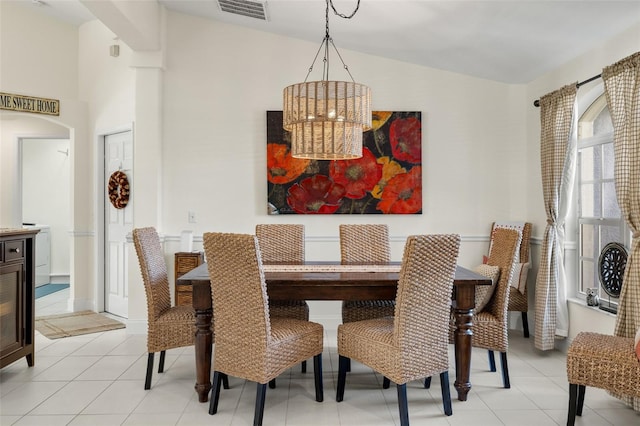 tiled dining room with an inviting chandelier