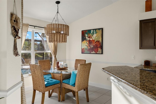 dining area featuring light tile patterned floors and vaulted ceiling