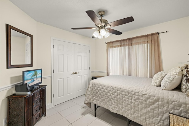 tiled bedroom featuring ceiling fan and a closet