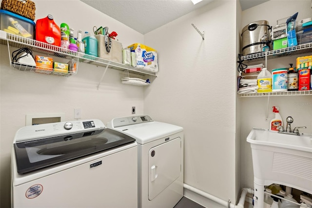 washroom featuring washer and clothes dryer, a textured ceiling, and sink